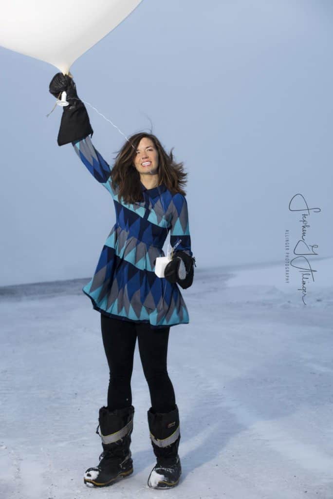Rebecca Burtney in winter clothing at Antarctica with a weather balloon in hand. Balanced lifestyle strategy