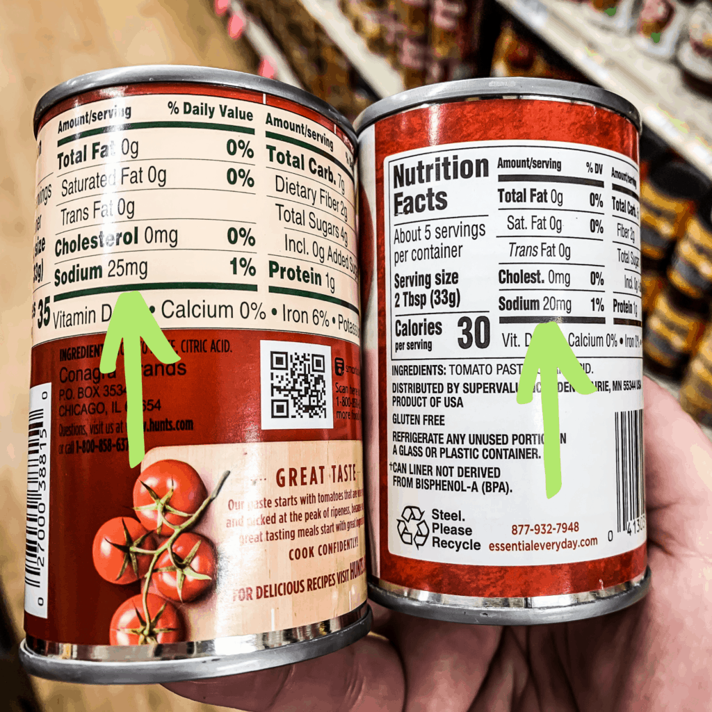 Two small cans of tomato paste side by side to discover which can has lower sodium in it