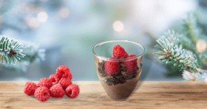 A vegan dessert cup of silken tofu chocolate mousse garnished with fresh raspberries