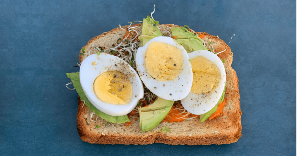 Avocado toast with egg gets a healthy upgrade with toppings including microgreens and romanesco sauce