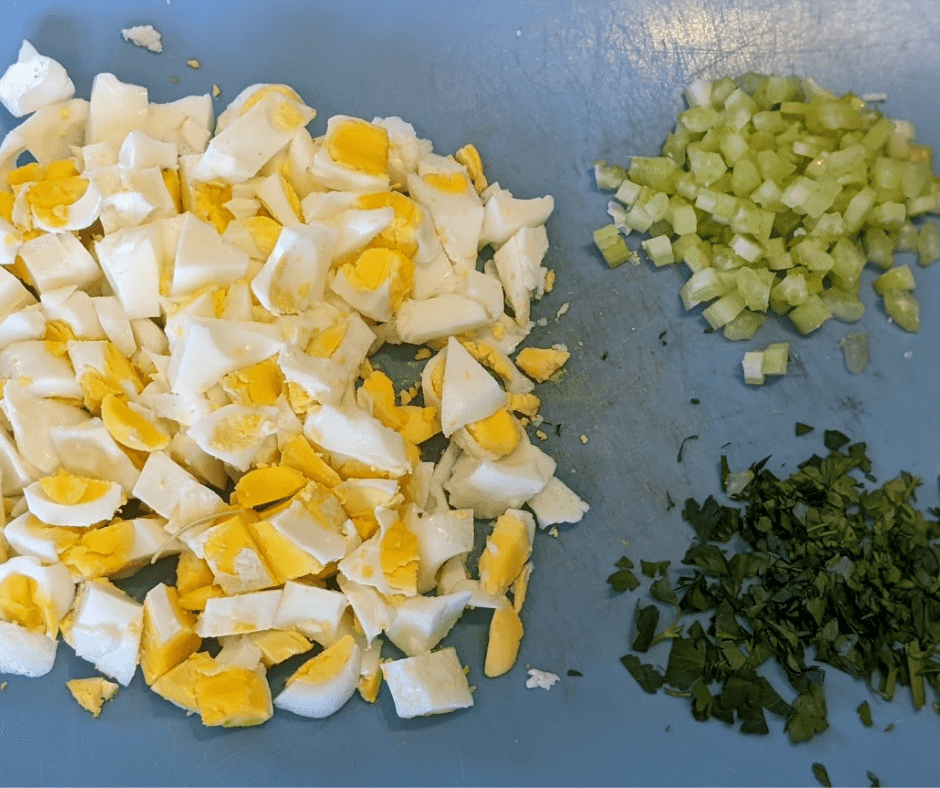 Ingredients for a healthier egg salad, chopped boiled eggs, diced celery and fresh parsley