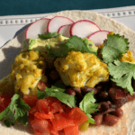 Fusion inspired vegan taco blends curry cauliflower and mexican flavors in a corn tortilla for the perfect handheld meal