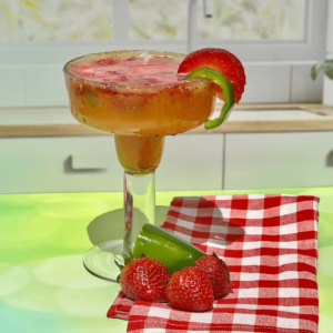 Non-alcoholic margarita in a glass with a fresh jalapeno for garnish and muddled strawberries.