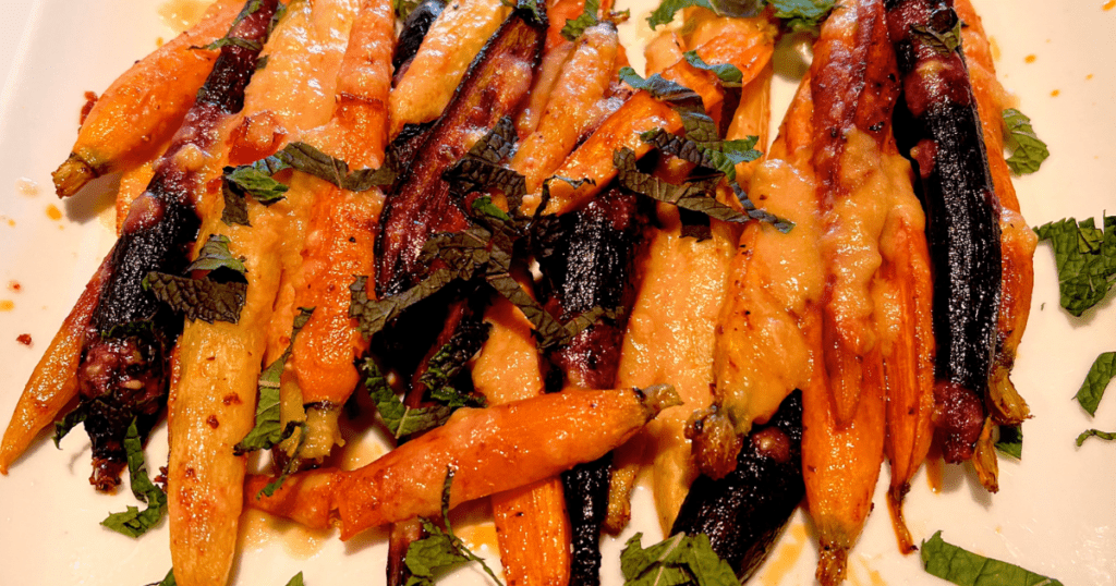 Harissa roasted carrots drizzled with lemon tahini dressing, taking this nutritious vegetable to the next level