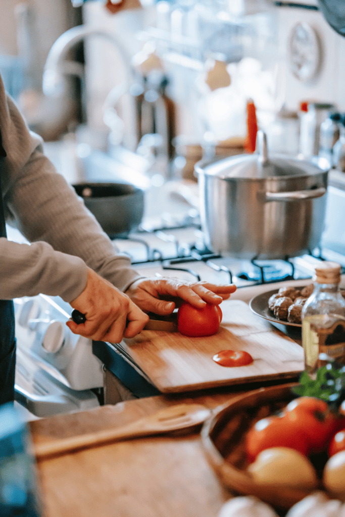 Cutting tomatoes, prepping food to make a healthy meal on an uncluttered counter