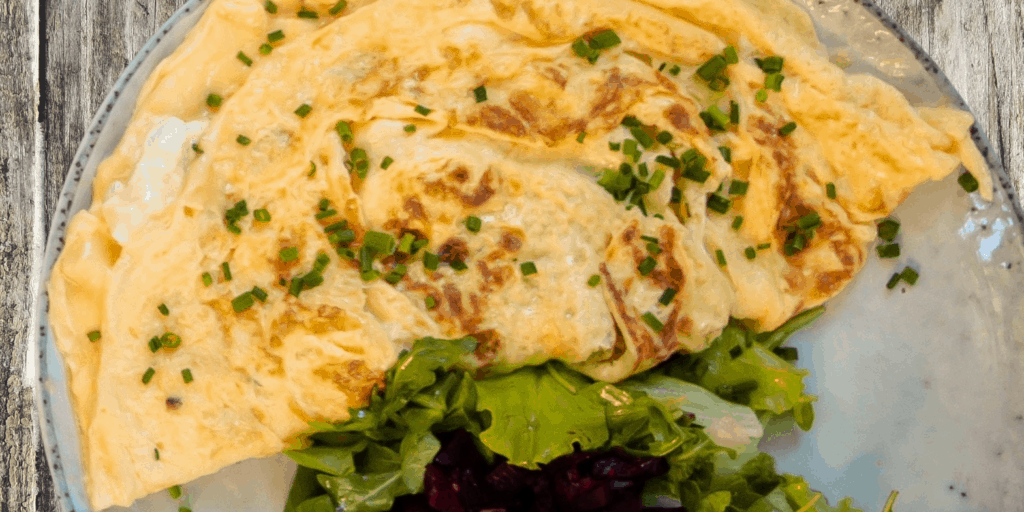 Spinach omelette plated with a side salad