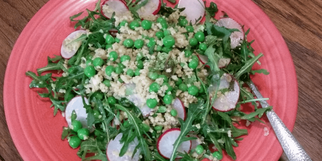 Radish and spring pea salad with baby arugula and farro grains, dressed with a lemon and mint vinaigrette