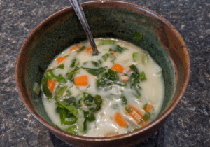 Bowl of homemade white bean soup with spinach, carrots and potatoes made in an instant pot.